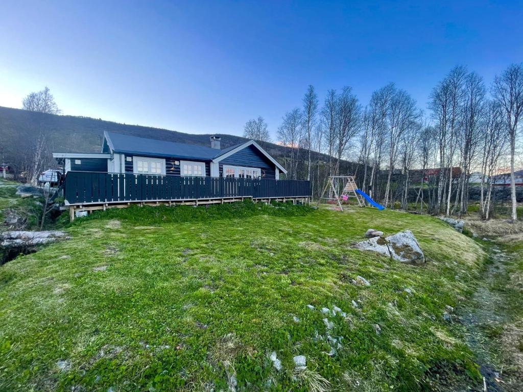 a house on a hill with a grassy yard at Stugu - Koselig hytte med sentral beliggenhet 