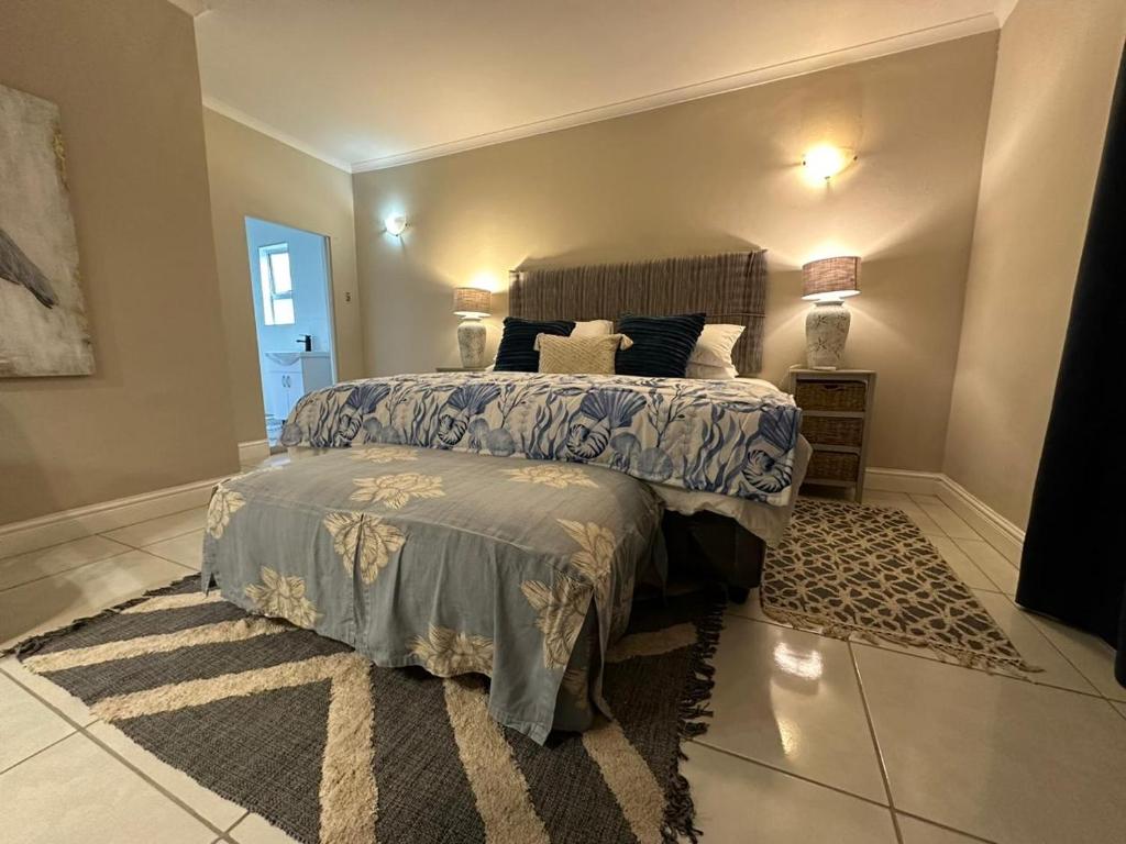 a bedroom with a large bed and a rug at On the Beach in Durban