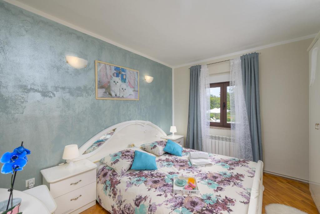 sypialnia z łóżkiem z narzutą w kwiaty w obiekcie Holiday Apartment Ariella w mieście Križanici