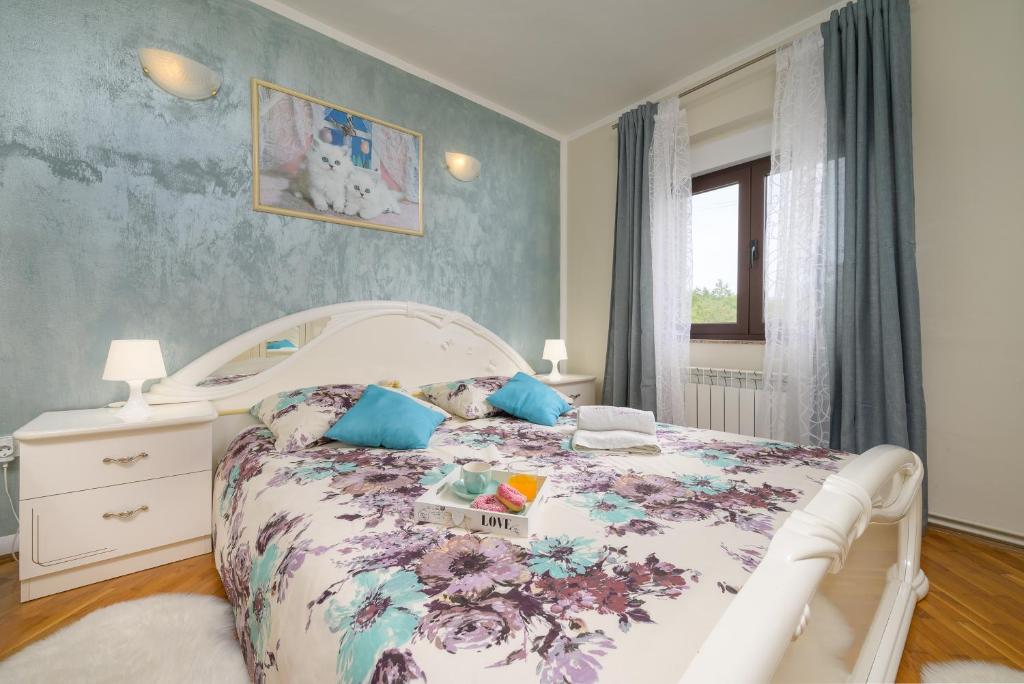 sypialnia z łóżkiem z narzutą w kwiaty w obiekcie Holiday Apartment Ariella w mieście Križanici