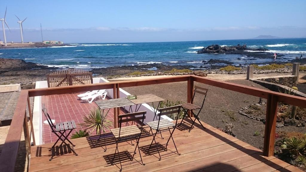 una terraza con mesa y sillas en la playa en The Inn, en Corralejo
