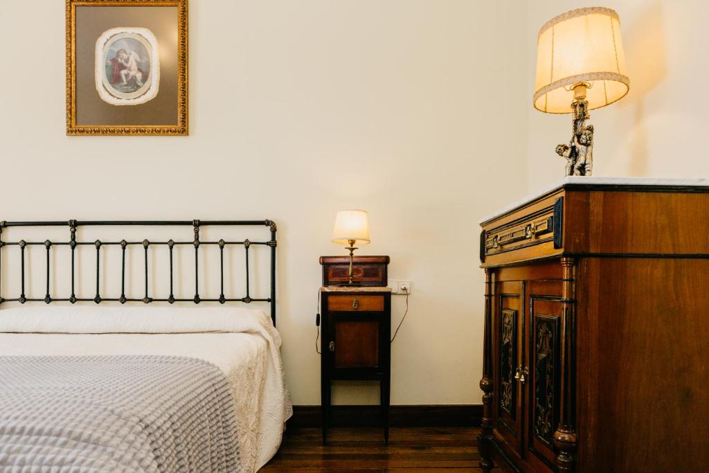 sypialnia z łóżkiem, komodą i lampą w obiekcie Pazo Almuzara w mieście Boborás