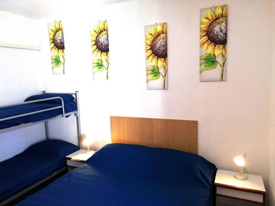 a bedroom with three sunflower paintings on the wall at Torre del Campese in Campese