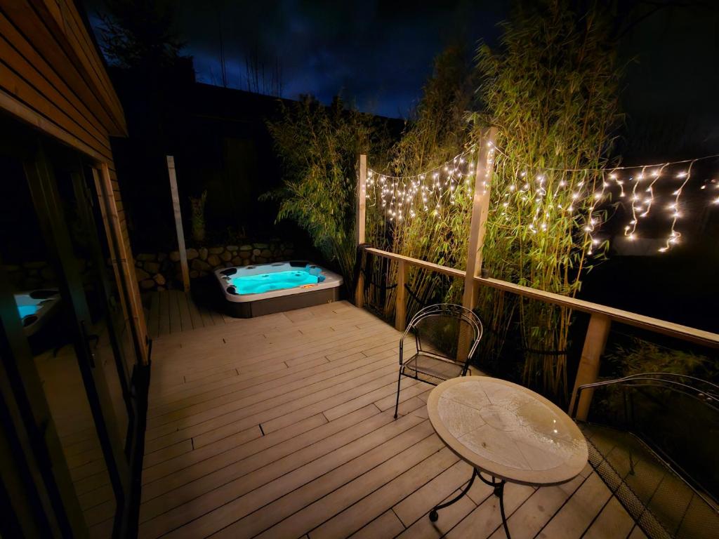 a deck with a tub and a chair and lights at Tiny House Flensburg Lee in Handewitt