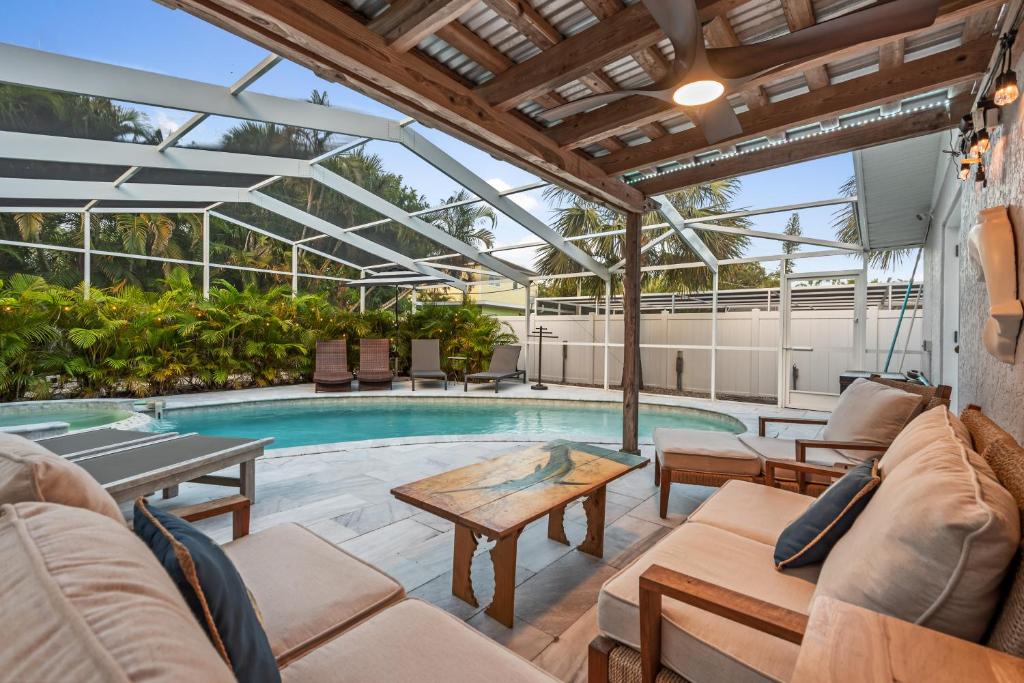 un patio al aire libre con piscina y mesa en Siesta Key Oasis with Outdoor Pool and Screened Lanai!, en Siesta Key