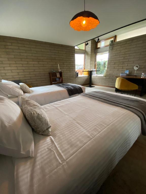 a bedroom with two beds with white sheets and pillows at L’Oxymore in Waimes