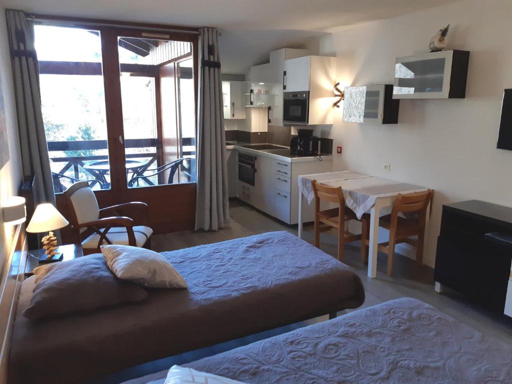 Cet appartement comprend une chambre avec deux lits et une cuisine avec un balcon. dans l'établissement Studio confortable avec balcon, parking et WiFi à Brides-les-Bains - FR-1-512-149, à Brides-les-Bains