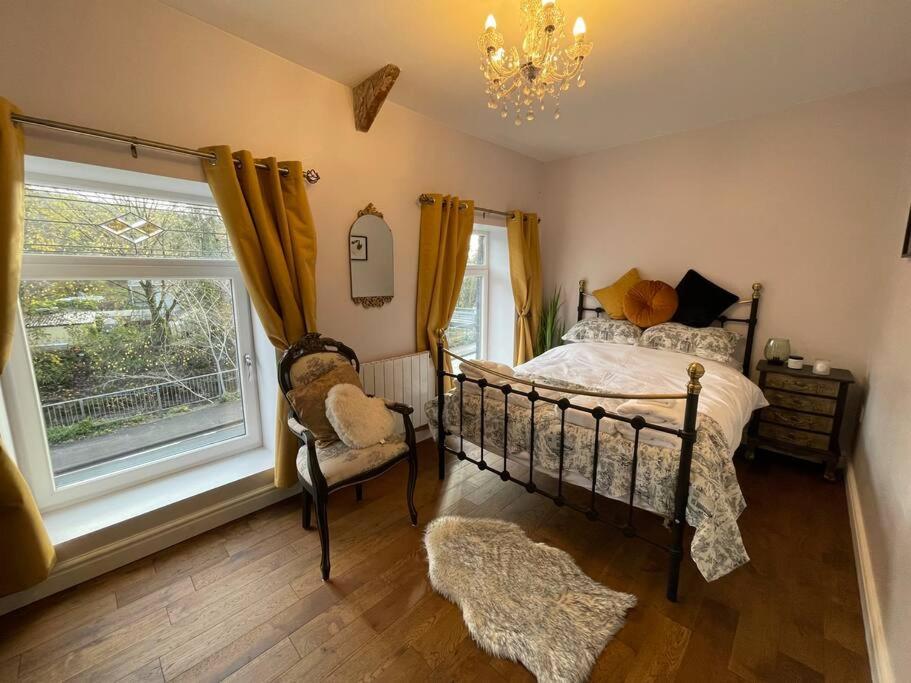 um quarto com uma cama, uma janela e uma cadeira em Bridgend Cottage em Abercraf