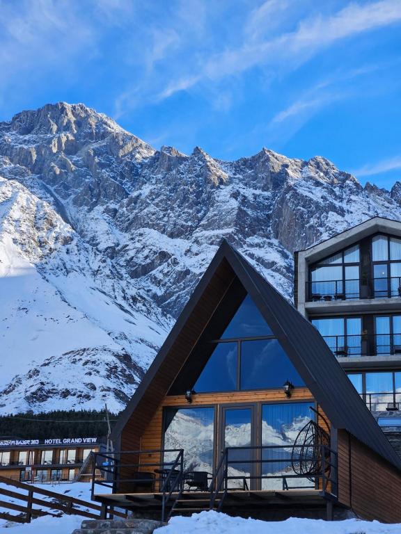 uma casa com uma montanha ao fundo em Misty Rocks Kazbegi em Stepantsminda