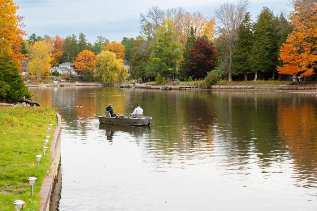 zwei Personen in einem Boot auf einem See in der Unterkunft Riverfront Cottage Sauna Canoe Included Kids Playroom Nature Escape in Wasaga Beach