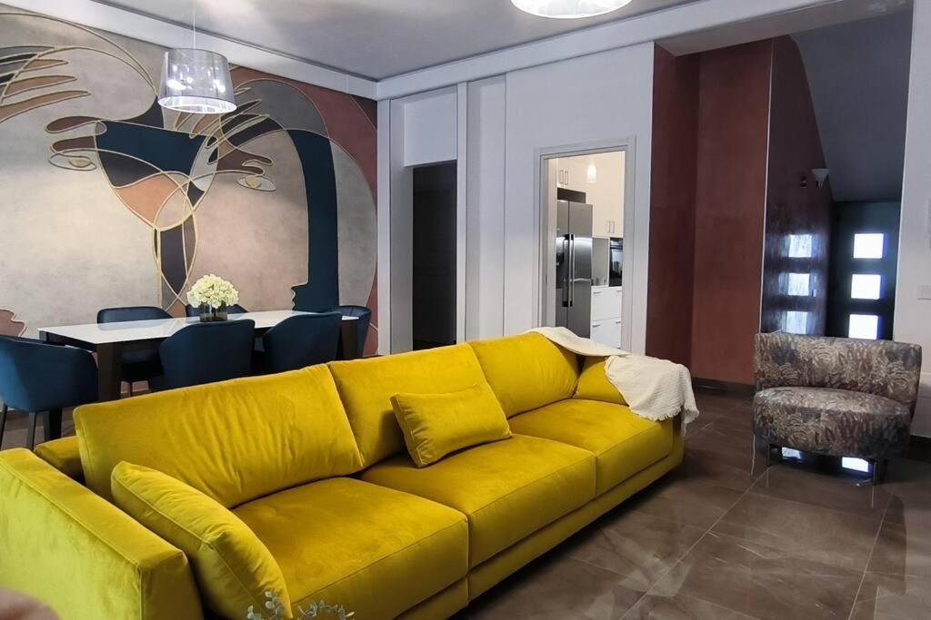 - un canapé jaune dans le salon avec une table dans l'établissement DimoraNOIDUE, à Locorotondo