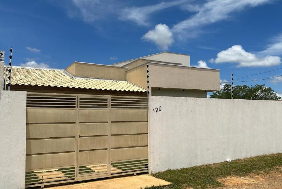 um edifício com uma porta de garagem ao lado de uma cerca em Bela casa nova na Chapada dos Guimarães em Chapada dos Guimarães