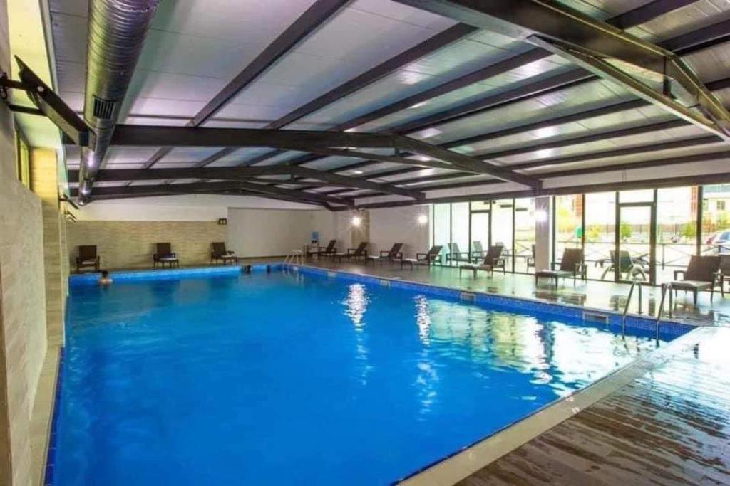 a large pool with blue water in a building at Crystal Residence Apartment 224 in Bakuriani