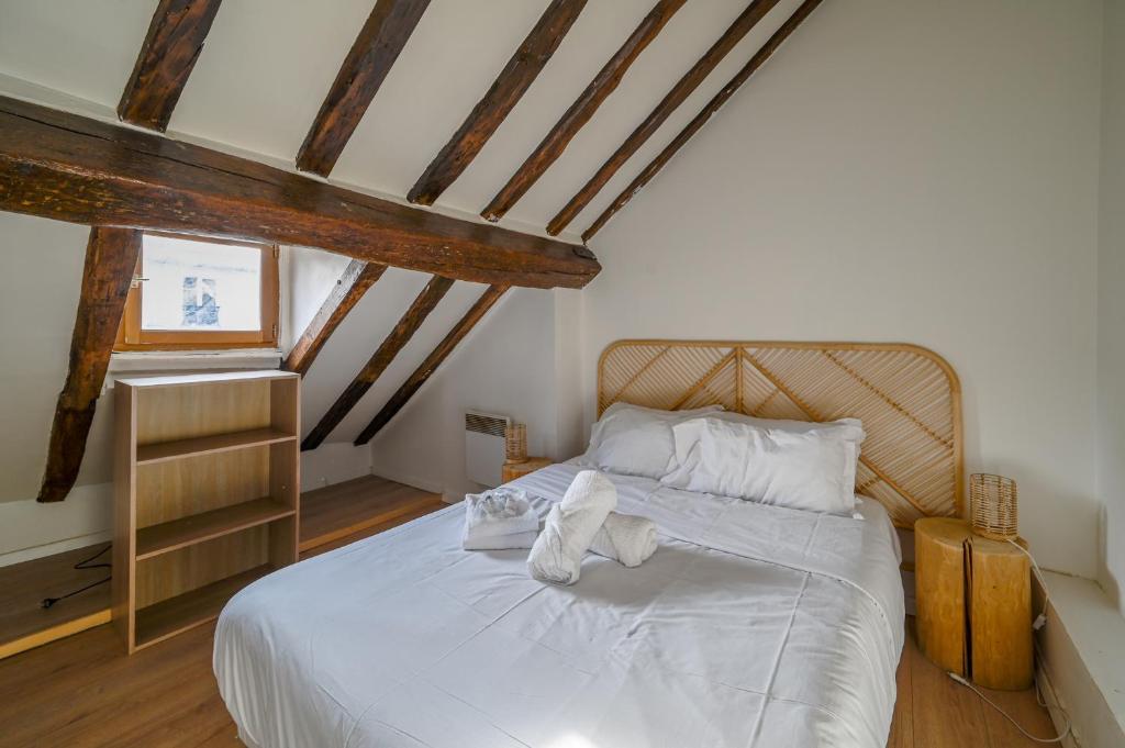 une chambre avec un lit avec des serviettes dessus dans l'établissement Cléry 58, à Paris