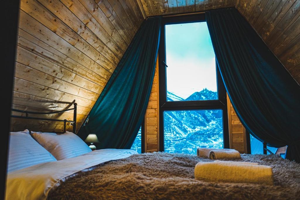 a bedroom with a bed and a large window at Morning Star Kazbegi in Stepantsminda