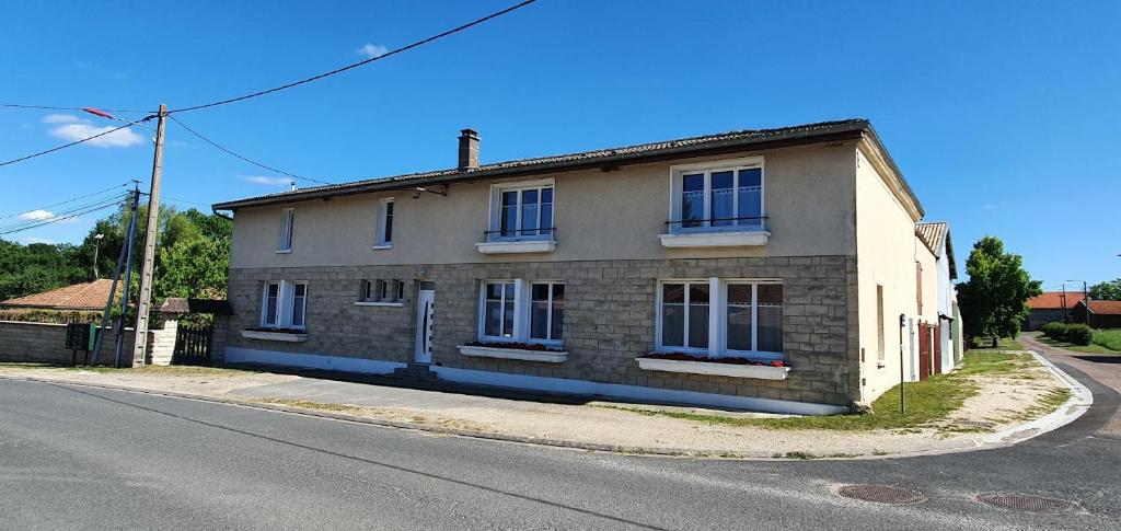 a brick house on the side of a street at Gîte Le Bois d Argonne in Le Vieil-Dampierre