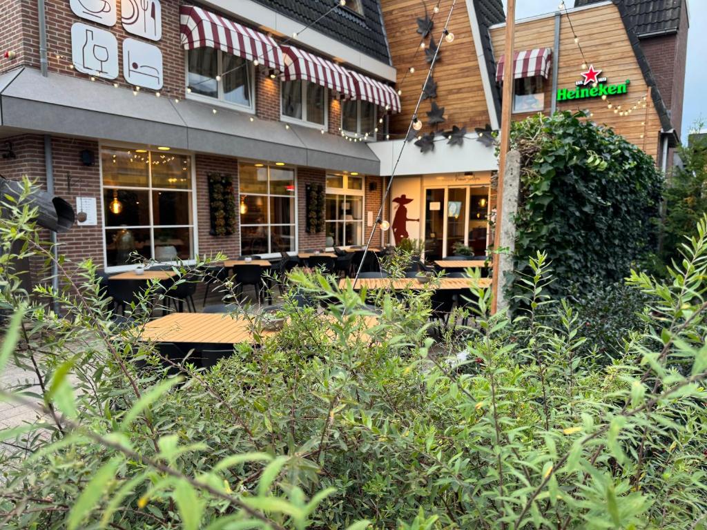 a building with a restaurant with a bunch of bushes at De Stobbe hotel & suites in Ruinen