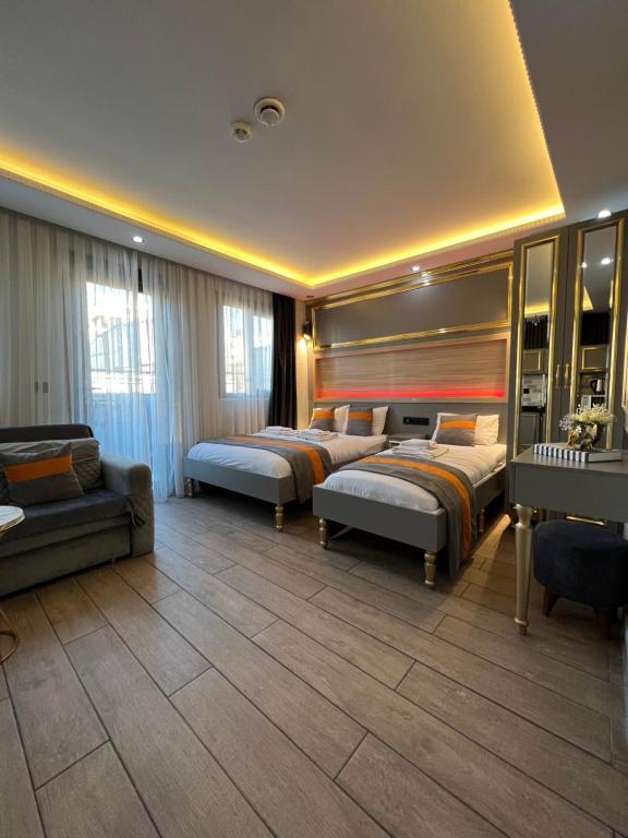 a hotel room with three beds and a couch at Taksim Larissa hotel suites in Istanbul