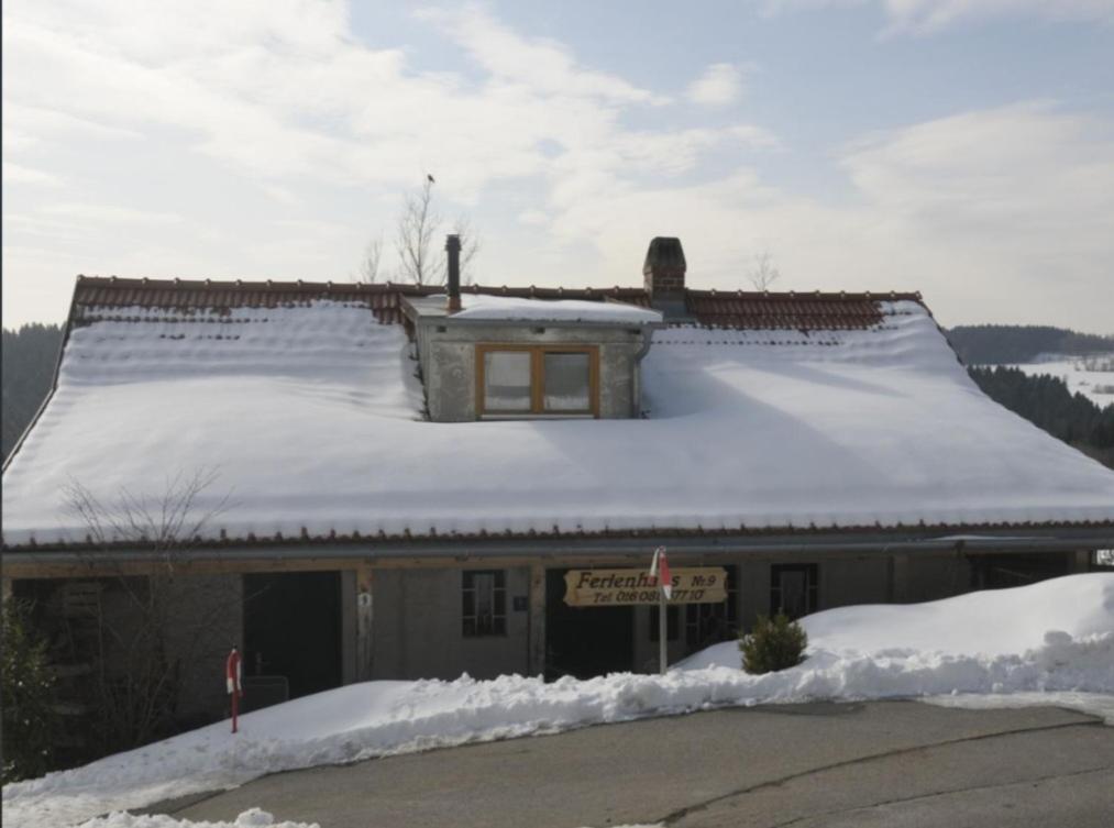 a building with snow on top of it at Ferienhaus Glashütt in Sankt Englmar