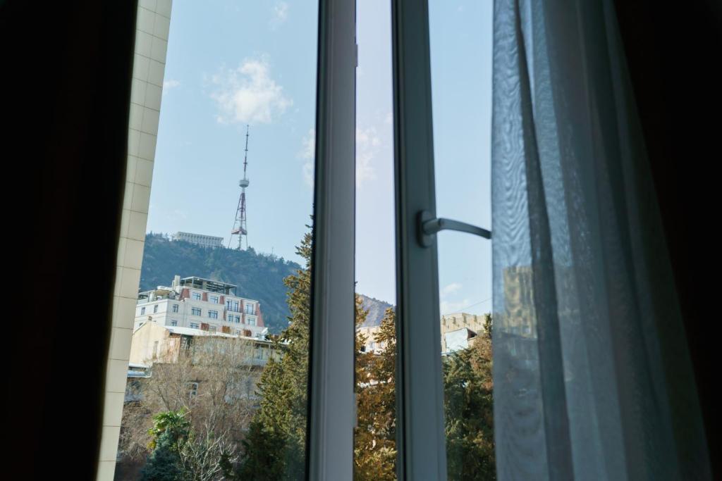 ein Fenster mit Bergblick in der Unterkunft Loft.tbilisi on Freedom Square in Tbilisi City