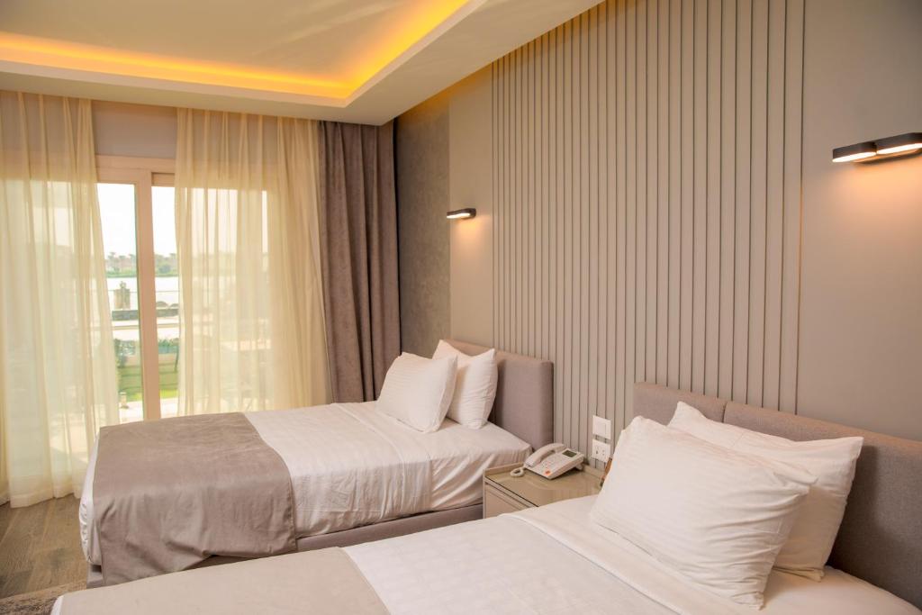 Postel nebo postele na pokoji v ubytování Nile Club hotel