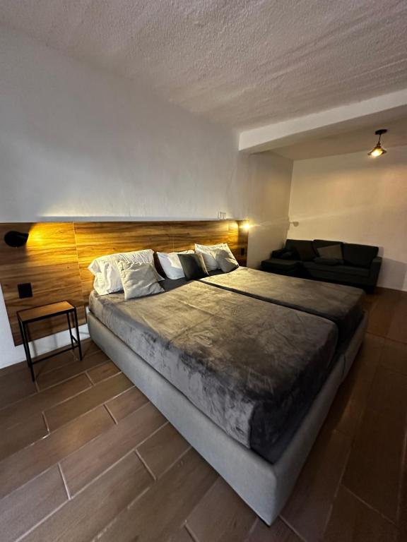 a bedroom with a large bed with a wooden headboard at Good Hostel in San Miguel de Allende