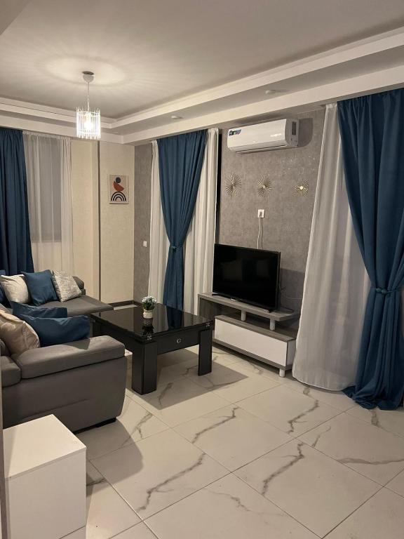 トビリシにあるTwo-Bedroom Apartment in Saburtalo Districtのリビングルーム(ソファ、テレビ付)