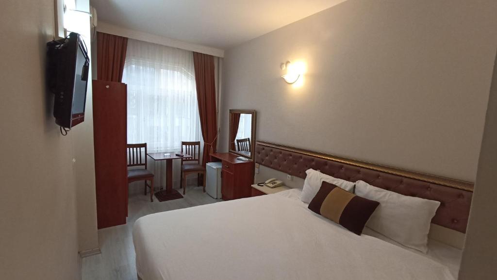 イスタンブールにあるトプカプ サベナ ホテルのベッドとテレビが備わるホテルルームです。