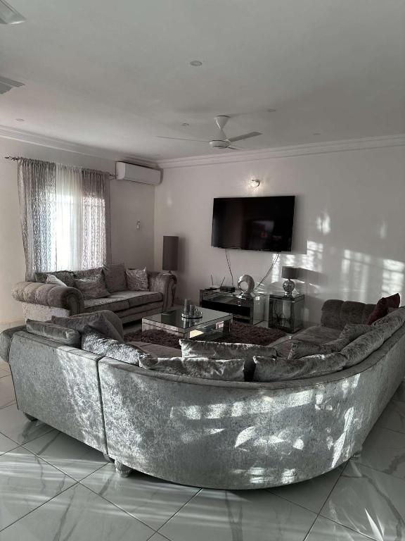 una sala de estar con un sofá grande en el centro en Luxury 2 bedroom flat KerrSerign, en Banjul