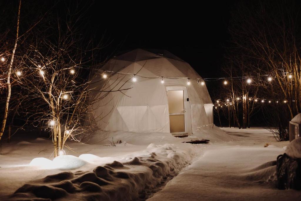 a tent with a door in the snow at night at Czorsztyn Glamp in Maniowy