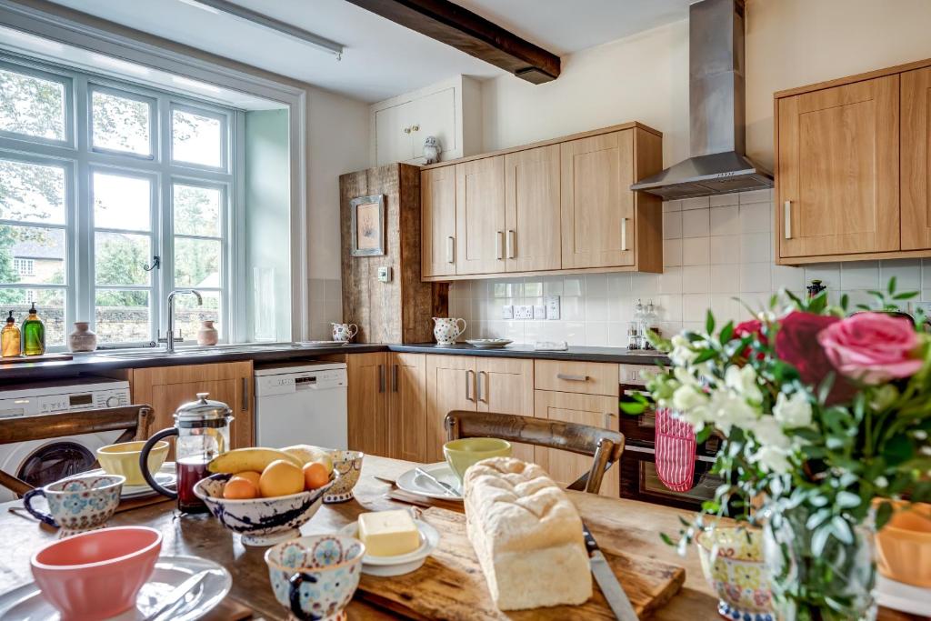a kitchen with a wooden table with food on it at The Bladon Farmhouse in Woodstock