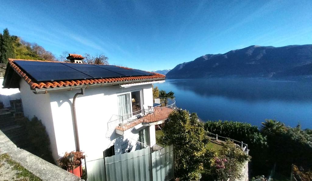 una casa con un panel solar en la parte superior de un lago en Avalon en Brissago