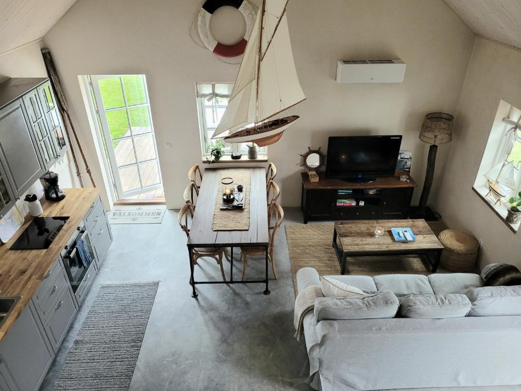 ein Wohnzimmer mit einem Sofa und einem TV in der Unterkunft Litet hus i mysig by nära havet in Ystad