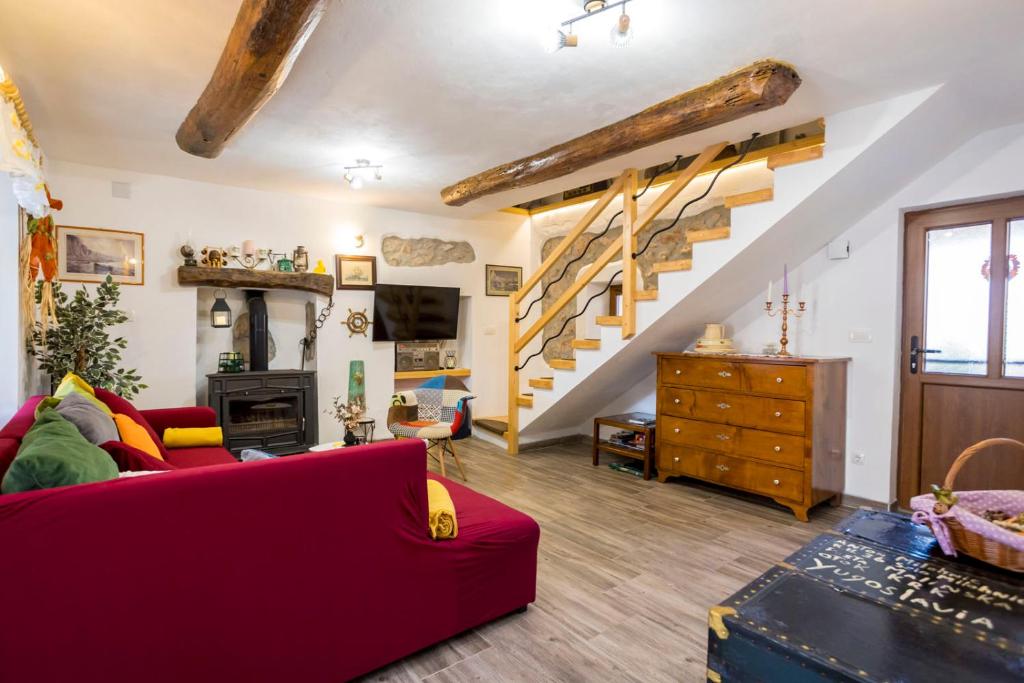 uma sala de estar com um sofá vermelho e escadas em Holiday Home Svjetlana em Risika