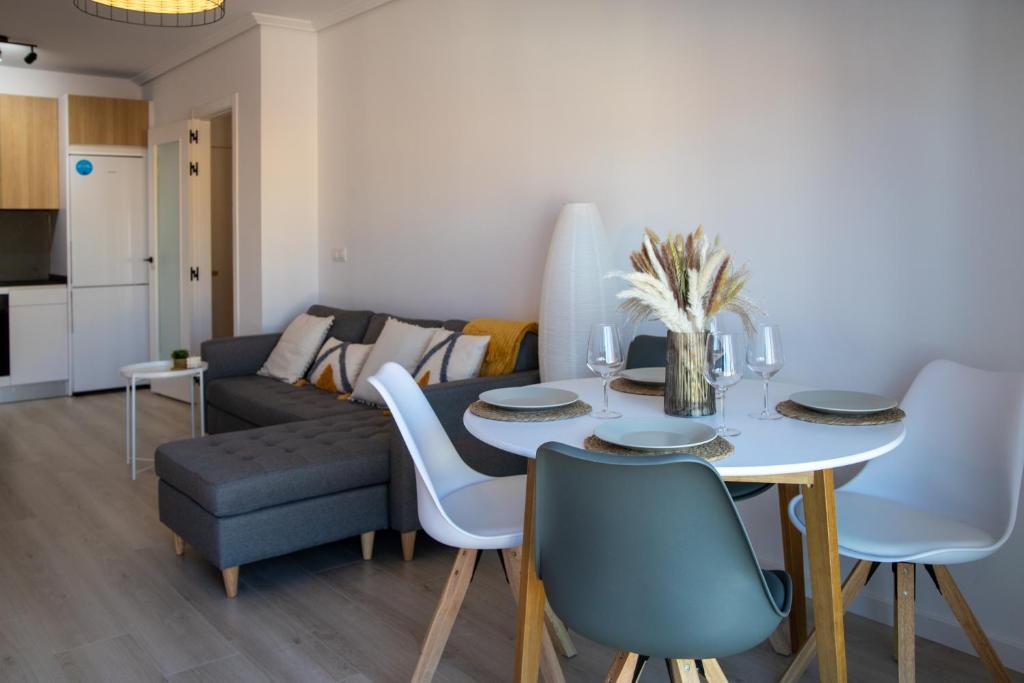 ein Wohnzimmer mit einem Tisch, Stühlen und einem Sofa in der Unterkunft O Son in Porto do Son