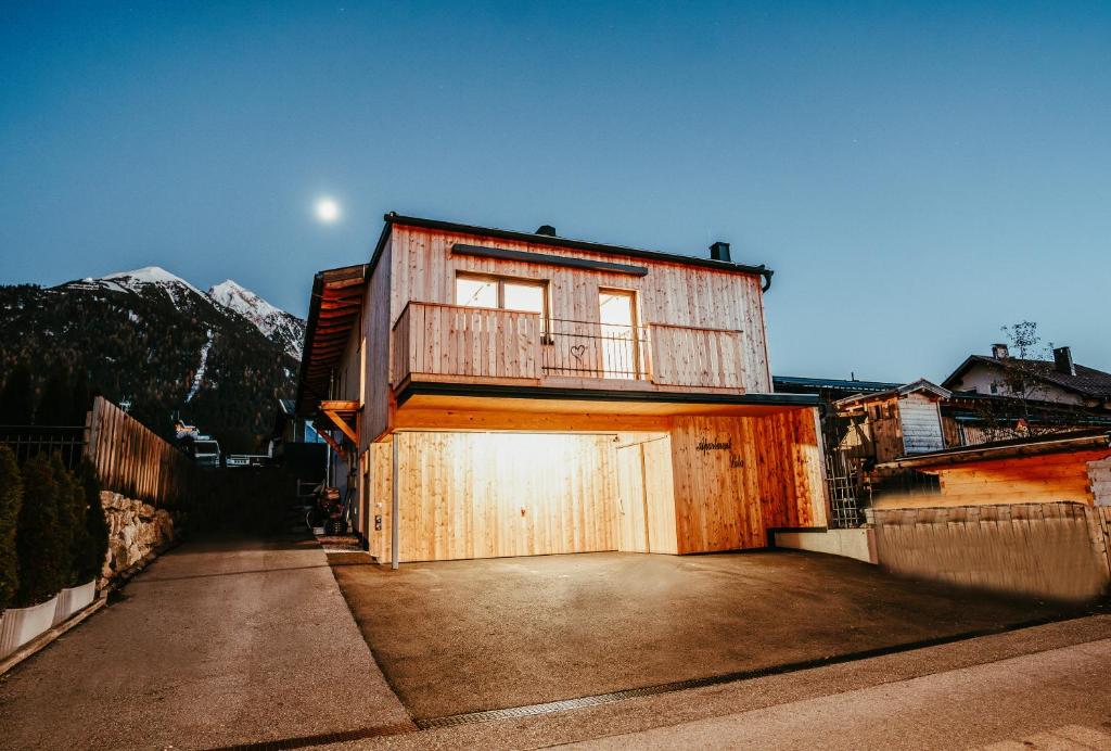 a building with a garage with a balcony on it at Apartment Lola in Seefeld in Tirol