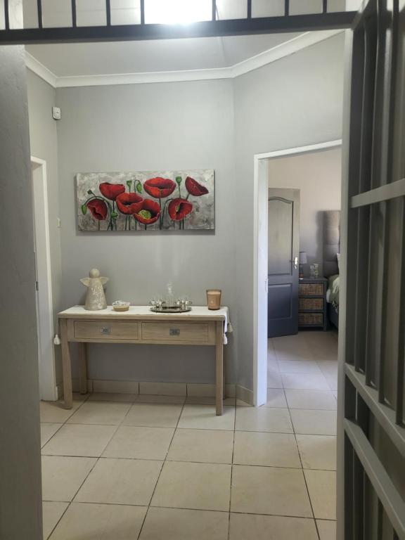 Habitación con mesa y pinturas en la pared. en Tranquility, en Bloemfontein