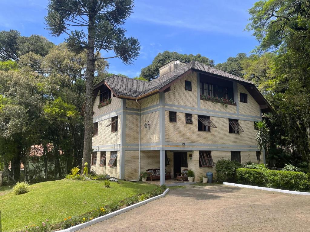 Casa blanca grande con ventanas y patio en Pousada Bella Serra en Canela