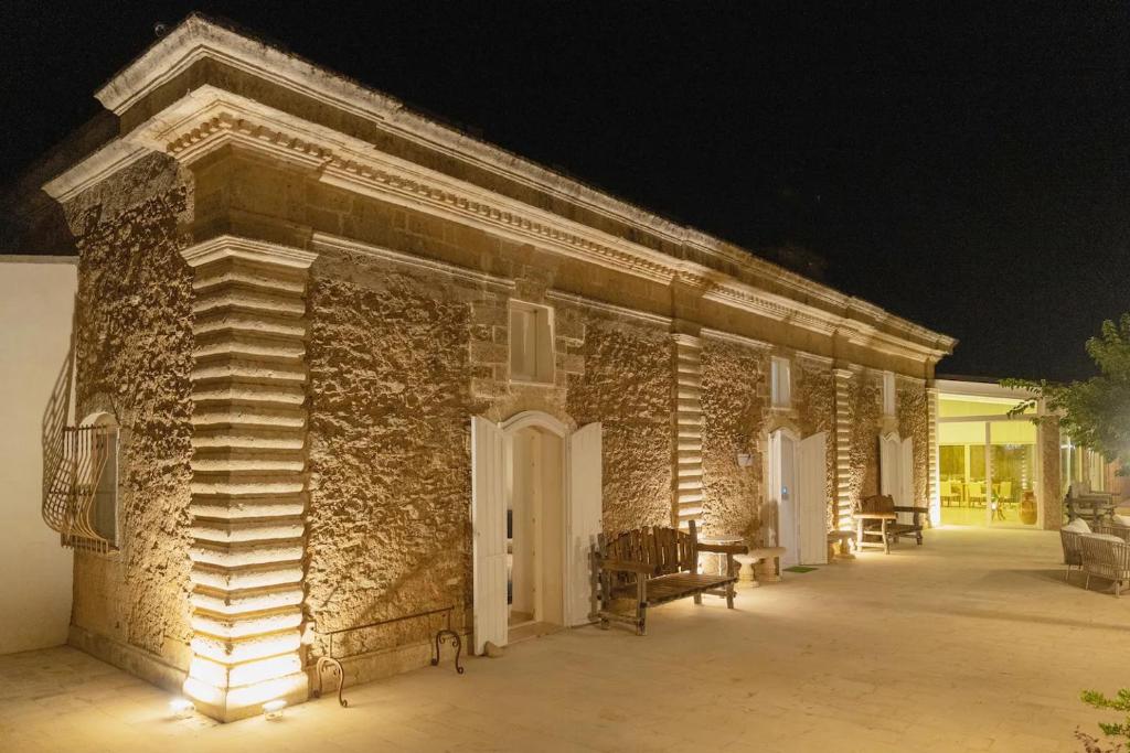 um edifício de tijolos com luzes acesas à noite em La volpe e l'uva Dimore em Montescaglioso