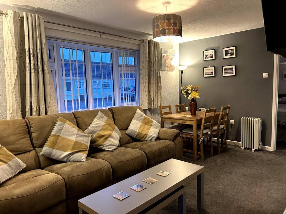 a living room with a couch and a table at Gorgeous Gower Chalet in Swansea