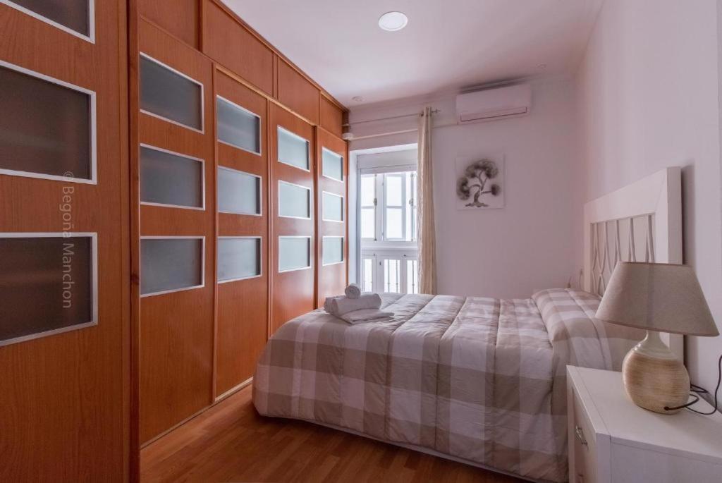 1 dormitorio con 1 cama y 1 mesa con lámpara en Apartamento Playa La Caleta en Cádiz