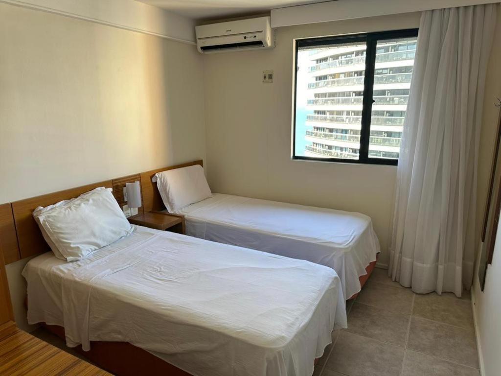 a hotel room with two beds and a window at apartamento com vista para o mar in Fortaleza