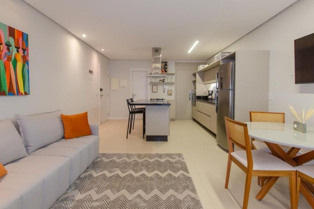 una sala de estar con un sofá y una mesa en Estúdio Estiloso no Pátio Milano, en Florianópolis