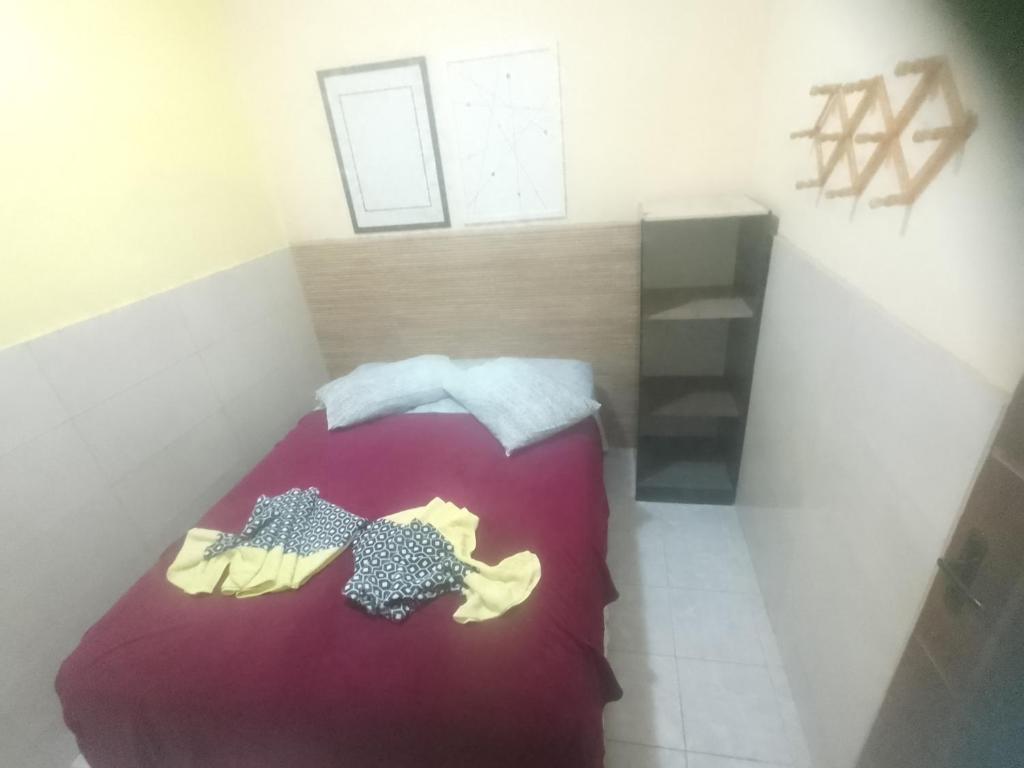 una piccola camera da letto con un letto con una coperta viola di Flat Porto a Porto De Galinhas