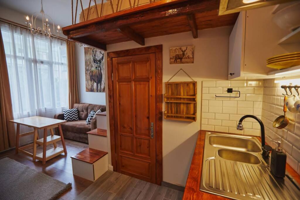 eine Küche mit einem Waschbecken und einem Sofa in einem Zimmer in der Unterkunft Unique hunter's hut concept tiny house 