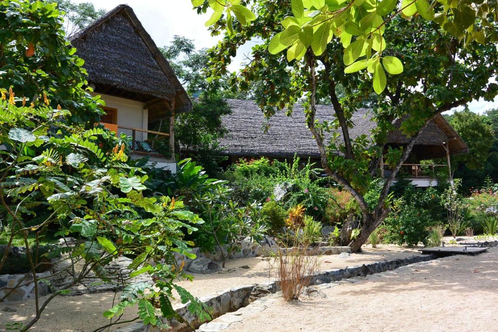 a garden in front of a house with trees at Coco Komba Lodge in Nosy Komba