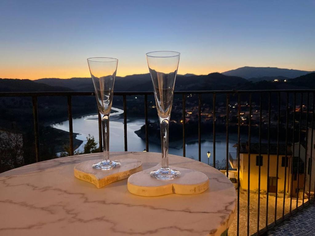 two champagne glasses sitting on a table on a balcony at Lake House in Sassocorvaro