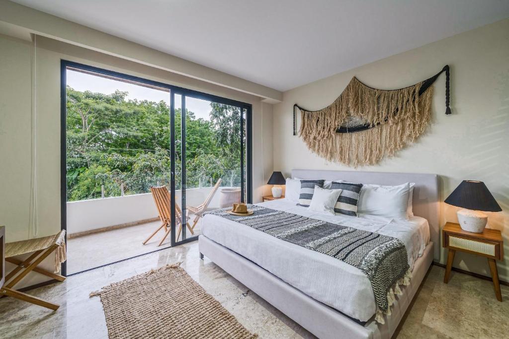 a bedroom with a large bed and a large window at Fast-Wifi Sunset Studio Tulum with Rooftop and Pool SPA in Tulum