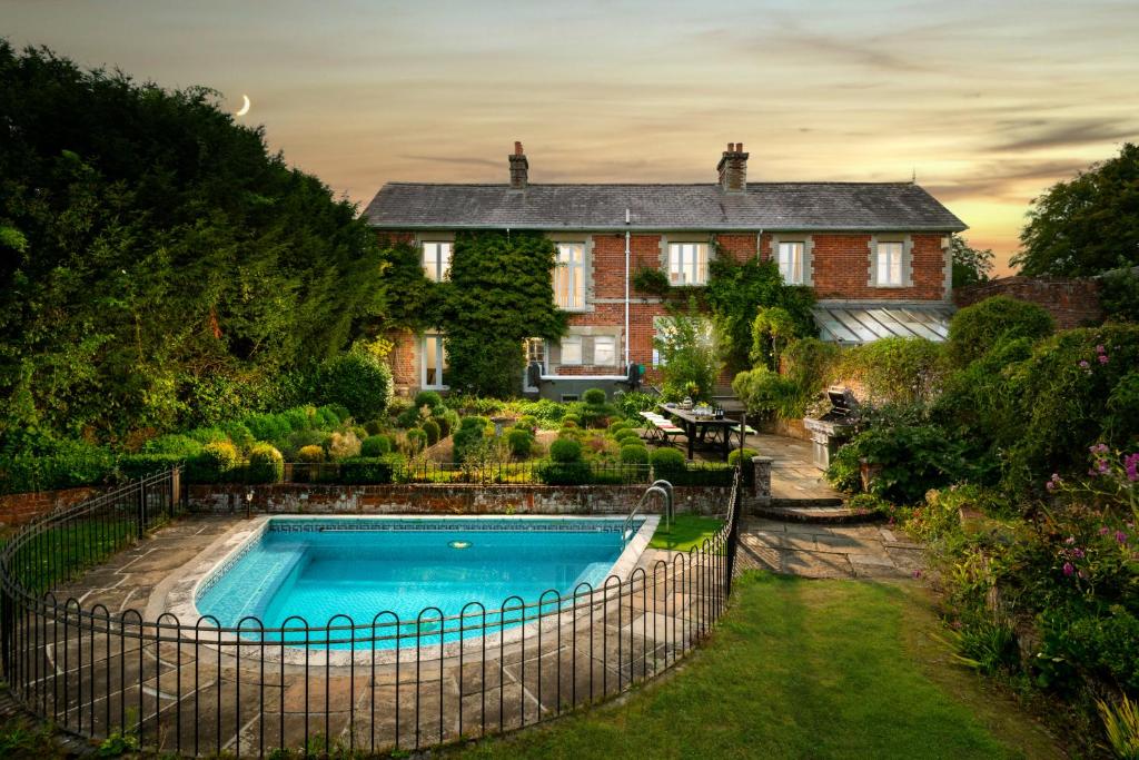 een huis met een zwembad in de tuin bij Downwood Vineyard Manor in Idyllic Countryside in Blandford Forum