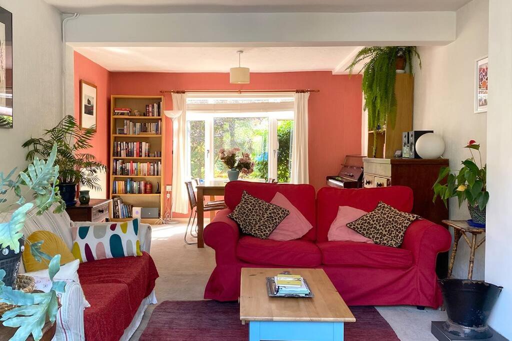 een woonkamer met een rode bank en een tafel bij 2BD Garden Hideaway in Lewes in Lewes